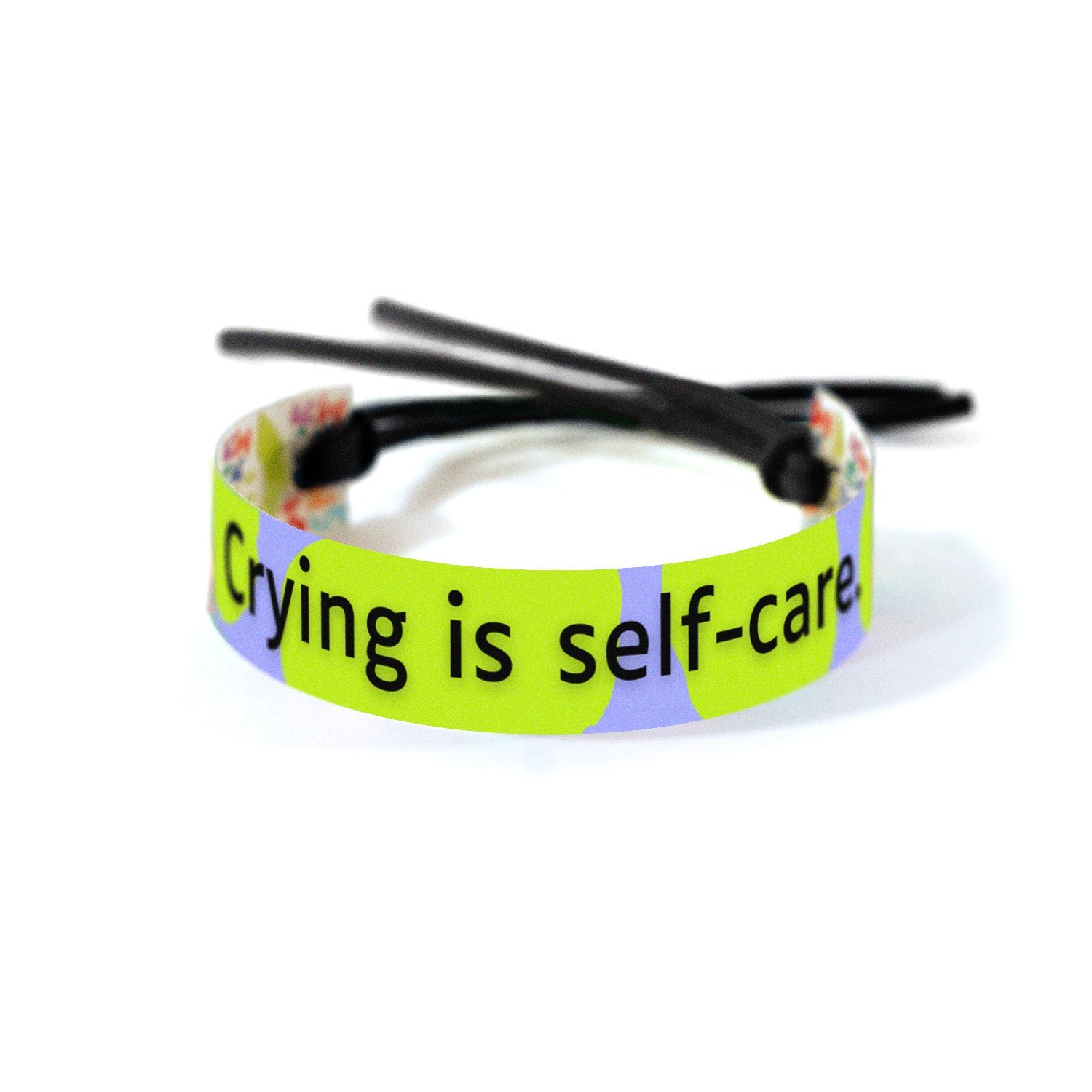 Bold black text of 'Crying is self-care.' set against a background of irregular green shapes on a light purple canvas showing big emotions as a form of healthy release.